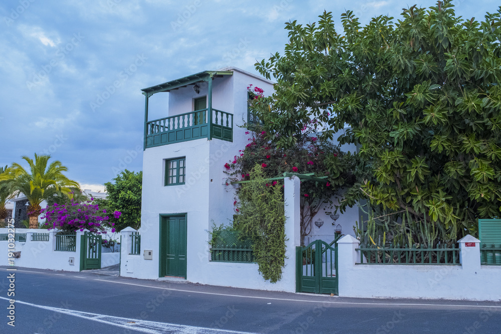 Obraz premium Small village Yaiza in Lanzarote island, white houses and palms at volcatic background. Canary islands, Spain
