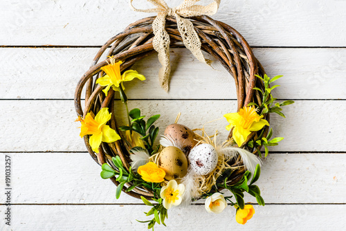 Easter background with spring easter eggs and flowers, wreath on door photo