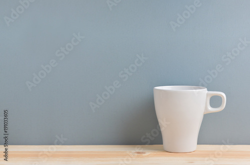 White cup of coffee on blue background.