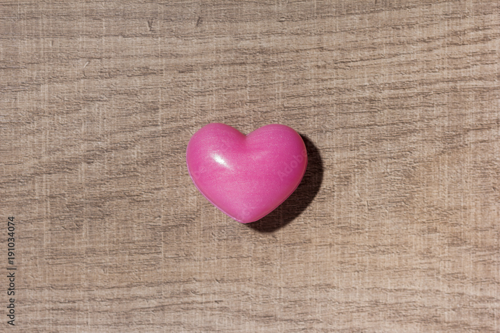 Red heart shape over wooden table. Overhead of romantic symbol of valentine day for background use. Concept of love, romance, and passion.