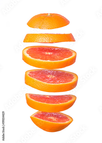 Creative concept with flying orange. Sliced orange isolated on white background. Levity fruit floating in the air.