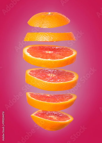 Creative concept with flying orange. Sliced orange isolated on white background. Levity fruit floating in the air.