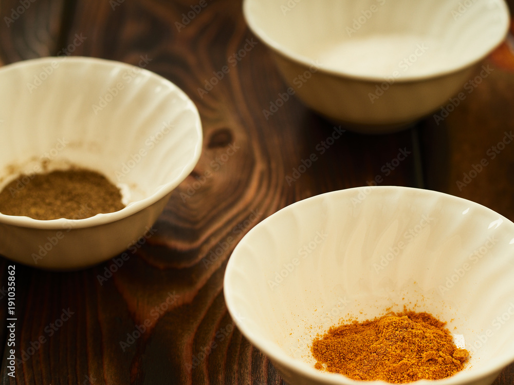 Spices in bowls, salt, pepper, turmeric.