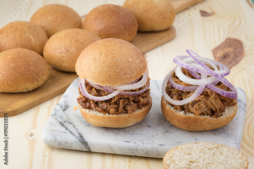 Pulled pork sandwich with BBQ sauce and onion.