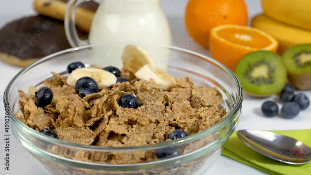 Fruits falling in slow motion on cereals flakes for breakfast Fruits falling in slow motion on cereals flakes for breakfast