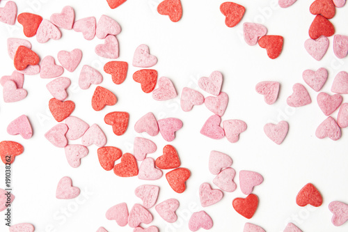 Close-up view of red and pink sugar hearts forming an abstract background pattern.