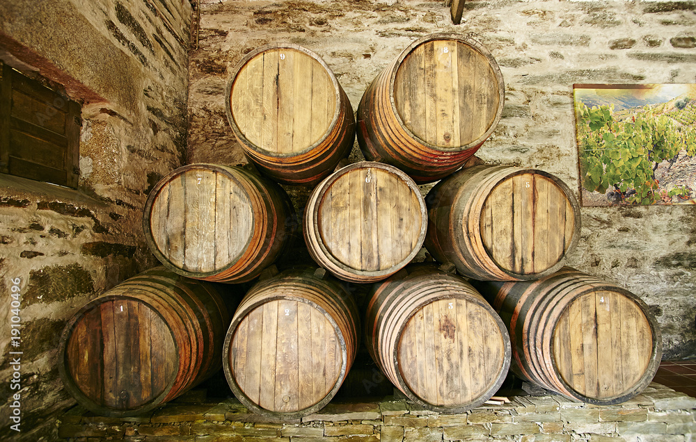 Large barrels of Porto wine stacked against the wall