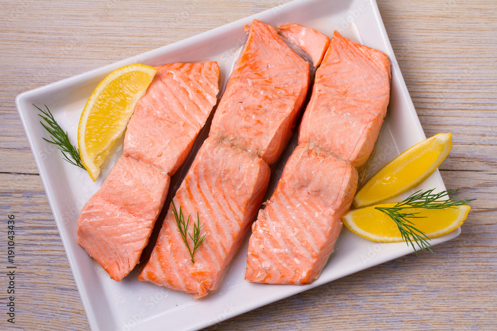 Boiled salmon on white plate. Poached salmon fillet. Good for health diet fish. View from above, top, horizontal Boiled salmon on white plate. Poached salmon fillet. Good for health diet fish. View from above, top, horizontal