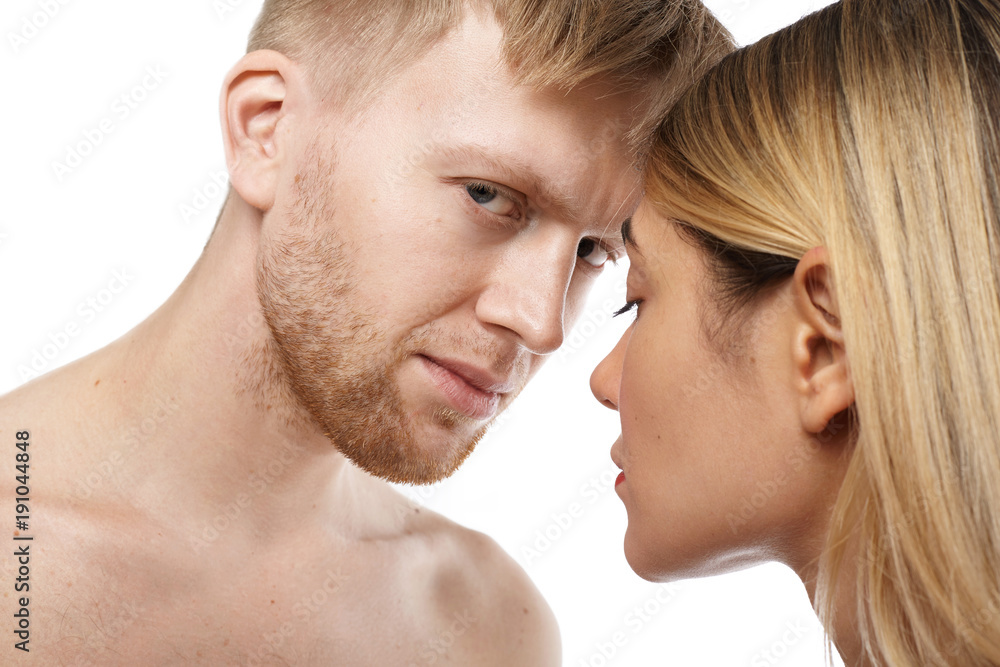 Close up isolated view of attractive shirtless unshaven Caucasian guy going to make love to beautiful tender blonde woman pic image