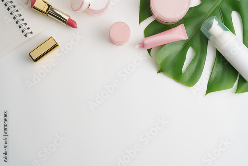 White cosmetic products and green leaves on white background. Natural beauty products for branding mock-up concept.