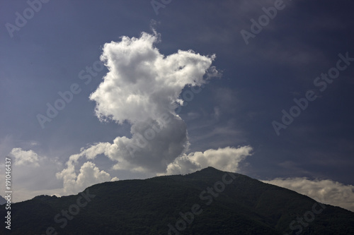 Cumulus cloud rises from the top of the mountain.