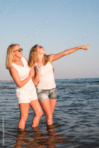Two blond girls on the beach near sea