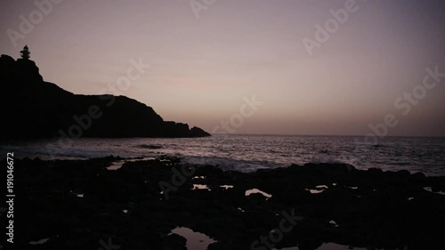 Sunset at rocky seashore.