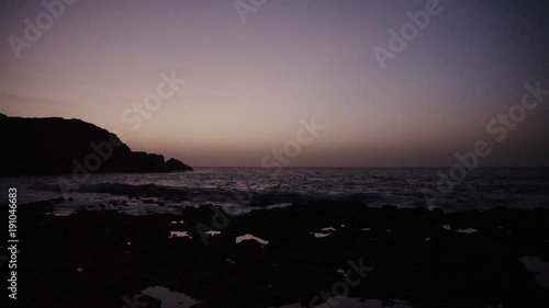 Sunset at rocky seashore.