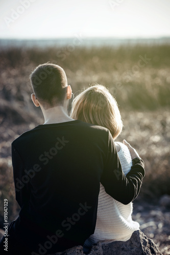 A loving couple is sitting in the arms on the lake.