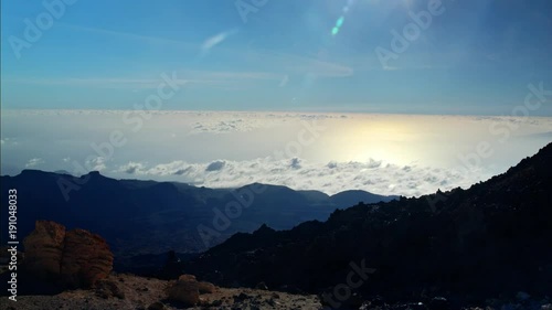 Clouds over the sea covering part oClouds over the sea covering part of the mountains of an island.f the mountains of an island.