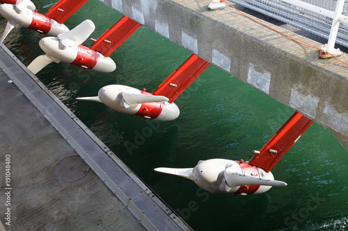 Tidal water turbines in a row above the river waiting for the tide