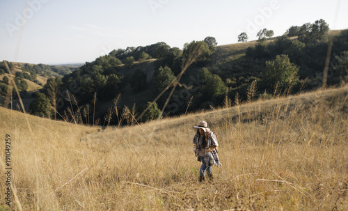 Woman Hiking in Field © LStockStudio
