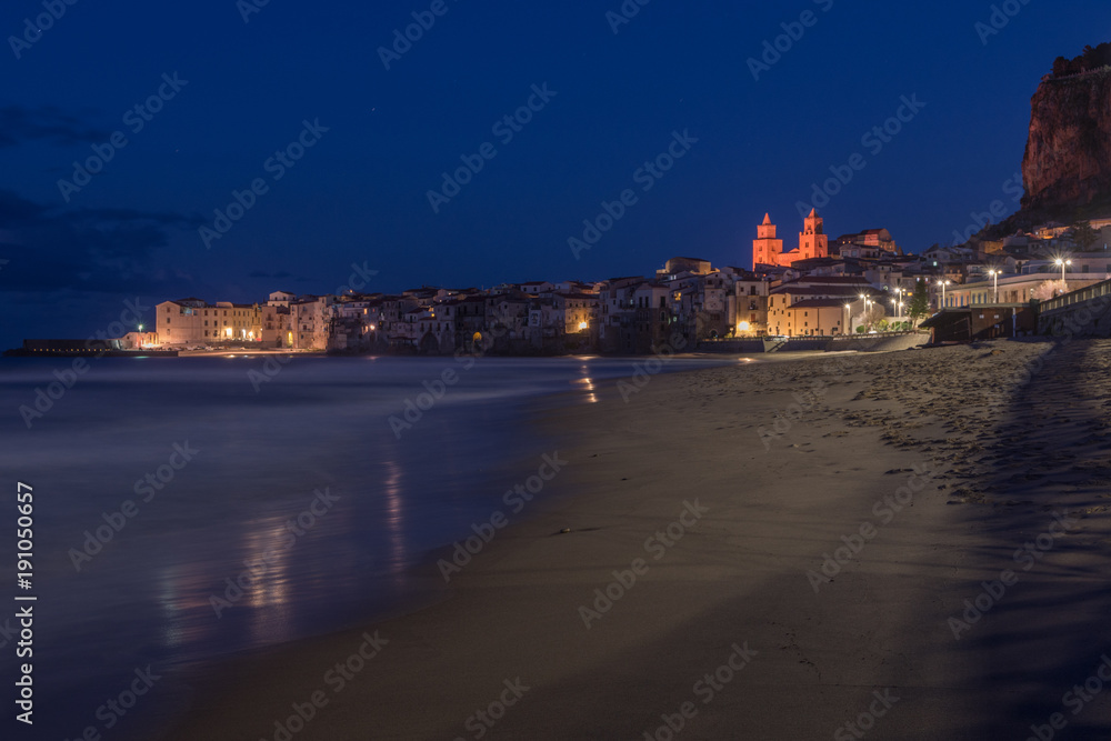Vista notturna della spiaggia di Cefalù con la cittadina sullo sfondo, Sicilia