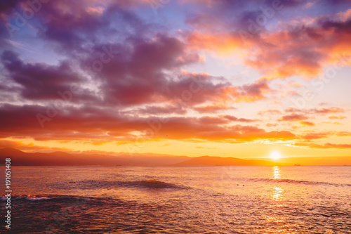 Bright sunset or sunrise in ocean. Landscape with warm sunset or sunrise colors