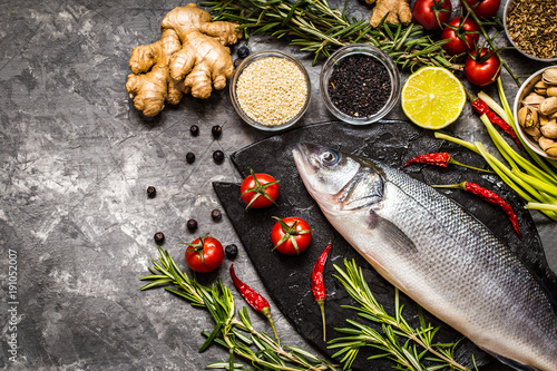 Fish, sea bass and ingredients for cooking: vegetables, spices, herbs