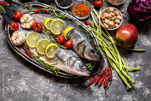 Fish, sea bass and ingredients for cooking: vegetables, spices, herbs photo