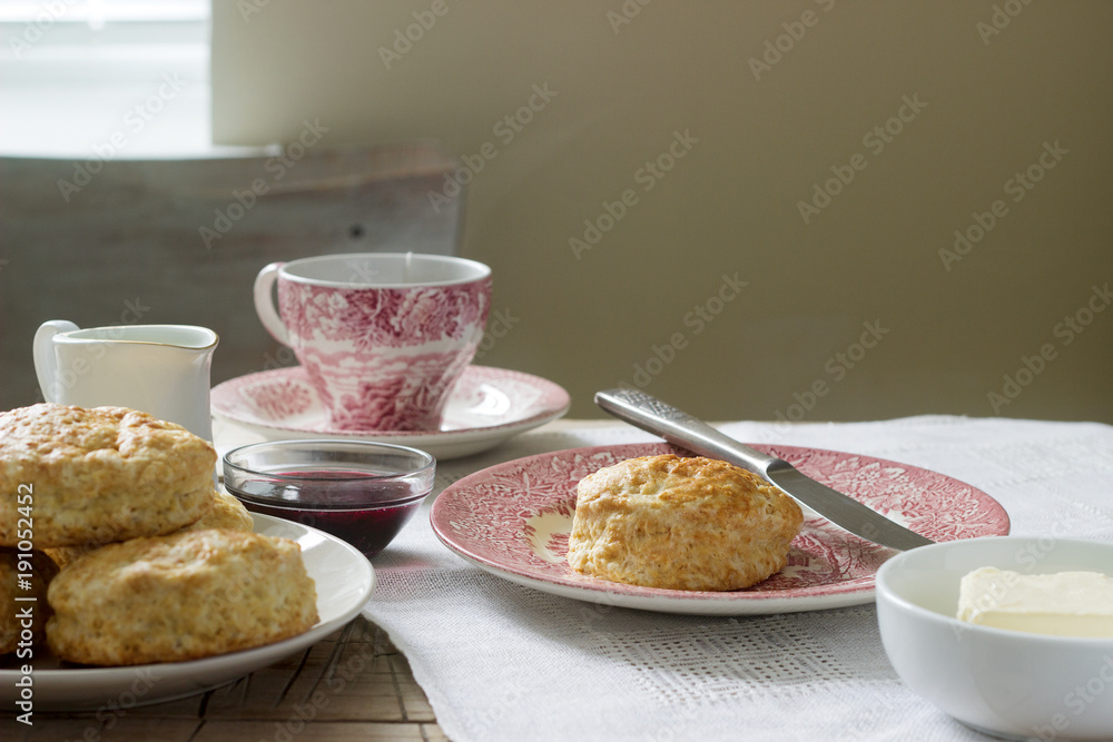 Homemade bread scones with hot tea, traditional British pastries.