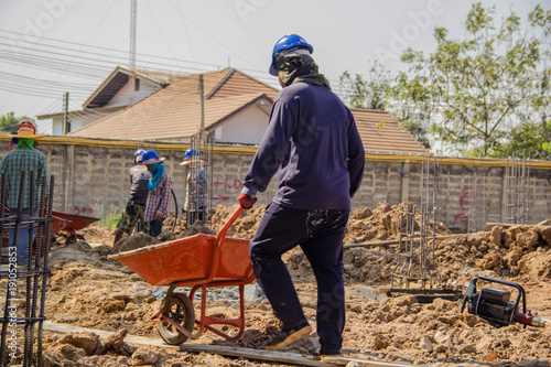 Construction worker pushing barrow