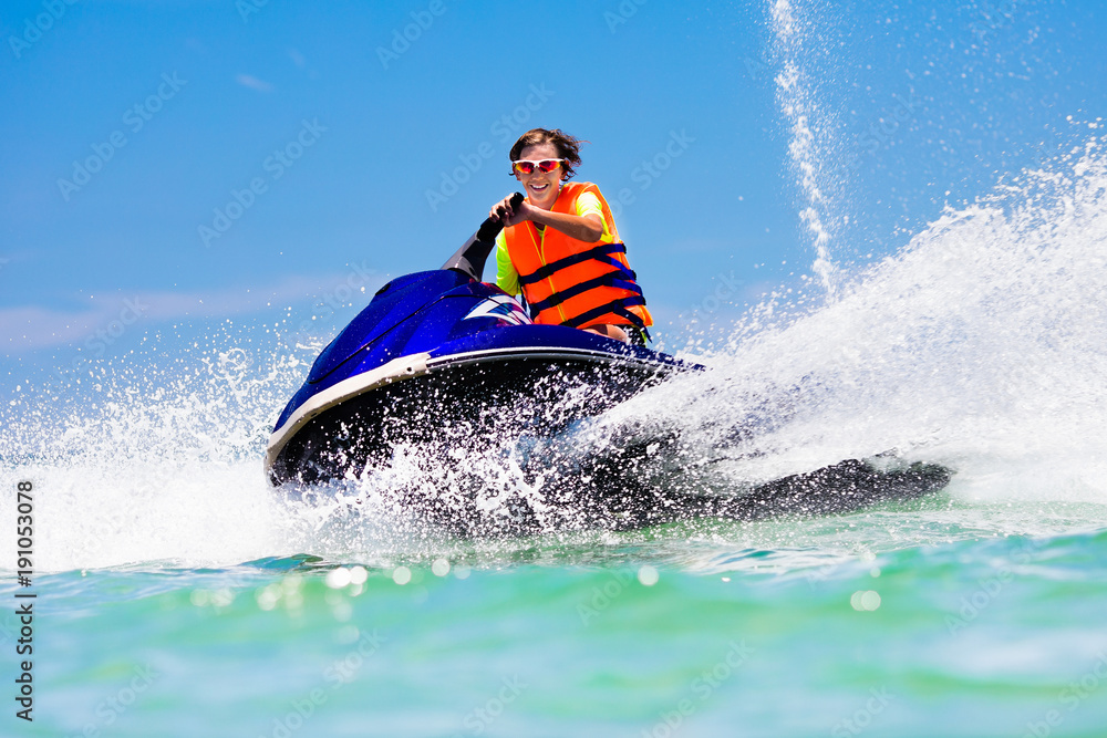 Teenager on jet ski. Teen age boy water skiing.