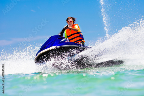Teenager on jet ski. Teen age boy water skiing. © famveldman