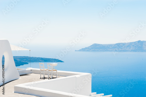 Two chairs on the terrace with sea views. Santorini island, Greece. Travel and vacation background