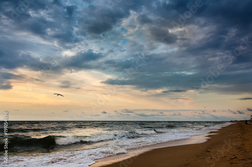 Dramatic sky on a morning seascape. Storm on a sandy sea beach.