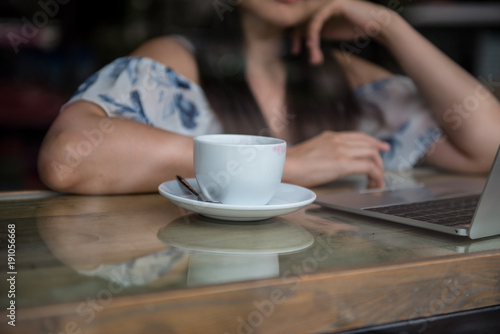 cup of coffee with working woman and her laptop illustrate working and relax concept