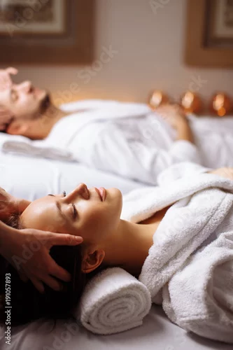 Obraz szczęśliwa młoda piękna para korzystających masaż głowy w spa