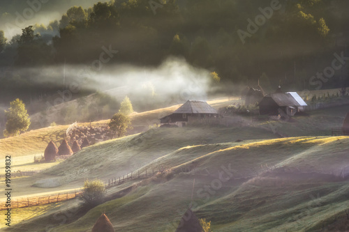 Beautiful rural mountain landscape in the sunrise light with morning fog, Fundatura Ponorului, Hunedoara County, Romania