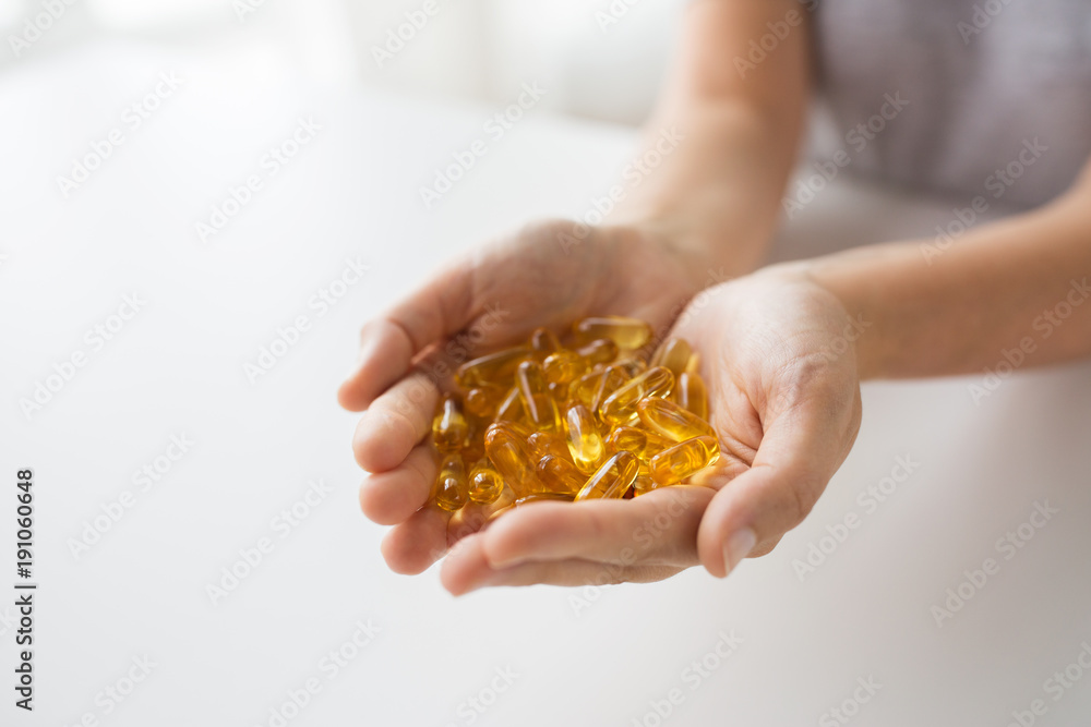 Obraz premium hands holding cod liver oil capsules