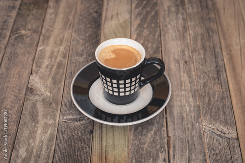 Single small coffee cup on wooden background