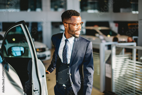 Wallpaper Mural Young african american driver opening his new car door Torontodigital.ca