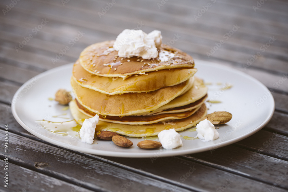 Image of some pancakes served on a plate on a wooden table. Image of some pancakes served on a plate on a wooden table.