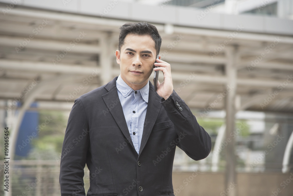 Handsome businessman asian talking on mobile phone. Handsome businessman asian talking on mobile phone.