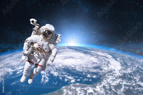 Fototapeta Naklejka Na Ścianę i Meble -  Astronaut in outer space on background of the Earth. Elements of this image furnished by NASA.
