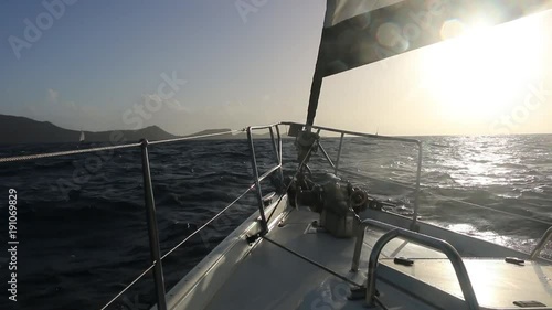 bow of a sail boat approaching an island photo