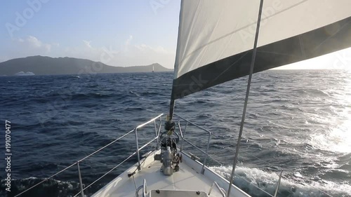 sailboat approaching a caribbean island photo