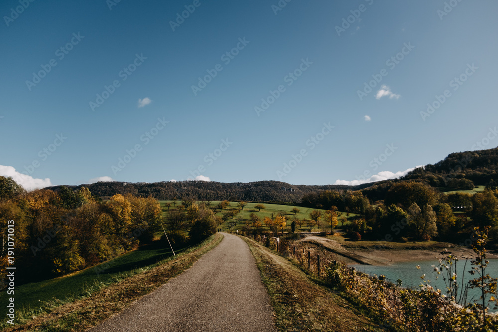 Fototapeta premium Sonniger Himmel mit Landschaft und Straße