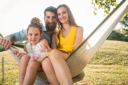 Familie erholt sich im Park in der Hängematte und genieß den Sommer