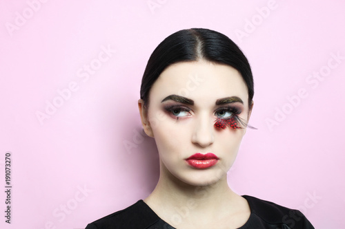 Beautiful girl, brunette with beautiful make-up in and lengthened eyelashes on a pink background.