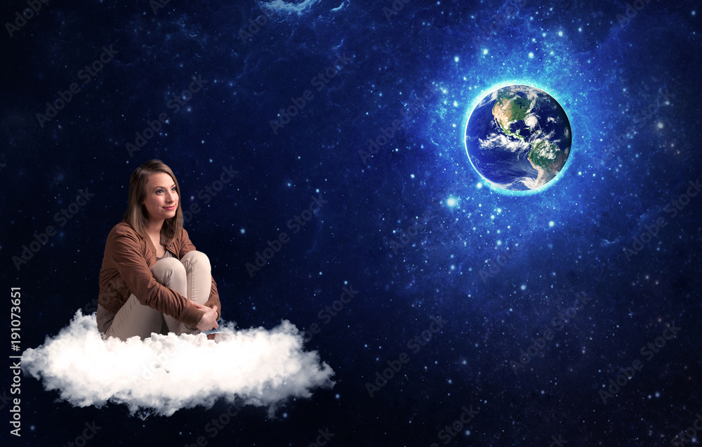 Woman sitting on cloud looking at planet earth Woman sitting on cloud looking at planet earth