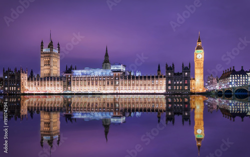 Big Ben und der Westminster Palast in London bei Nacht mit Reflektionen in der Themse