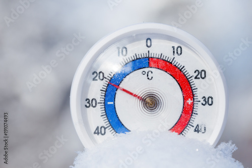 Outdoor thermometer in snow shows minus 21 Celsius degree cold winter weather concept photo