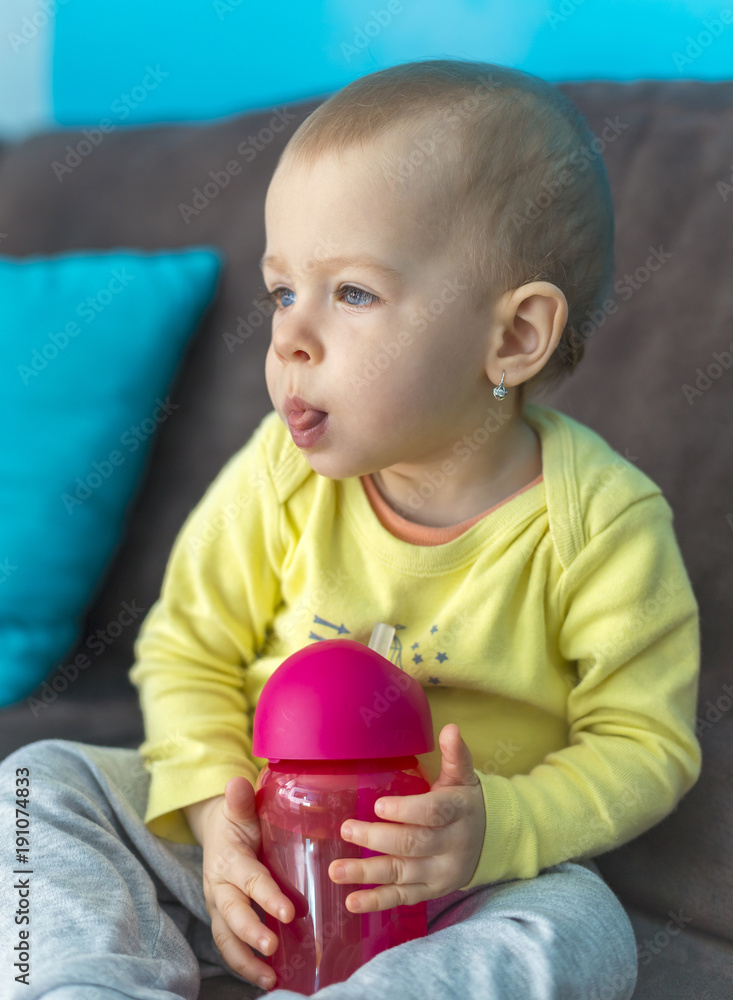 baby with blue eyes holding bottle baby with blue eyes holding bottle